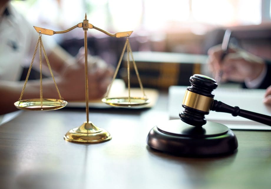 A judge 's gavel and scale on top of a table.